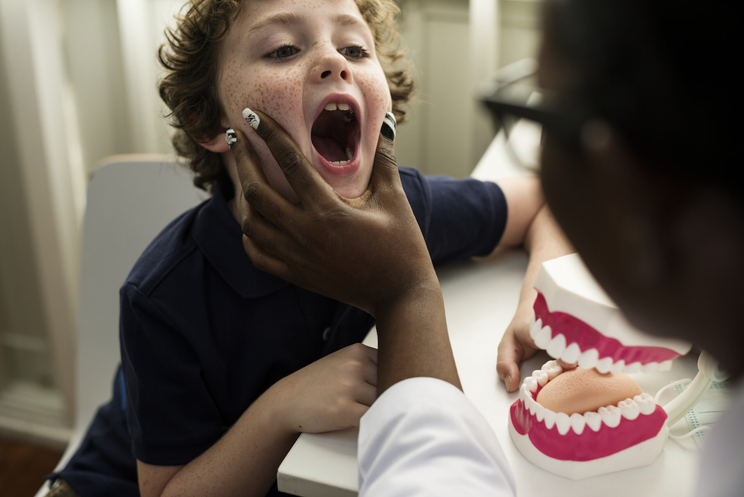 Menino consultando com uma dentista. Imagem ilustrativa sobre cárie infantil.