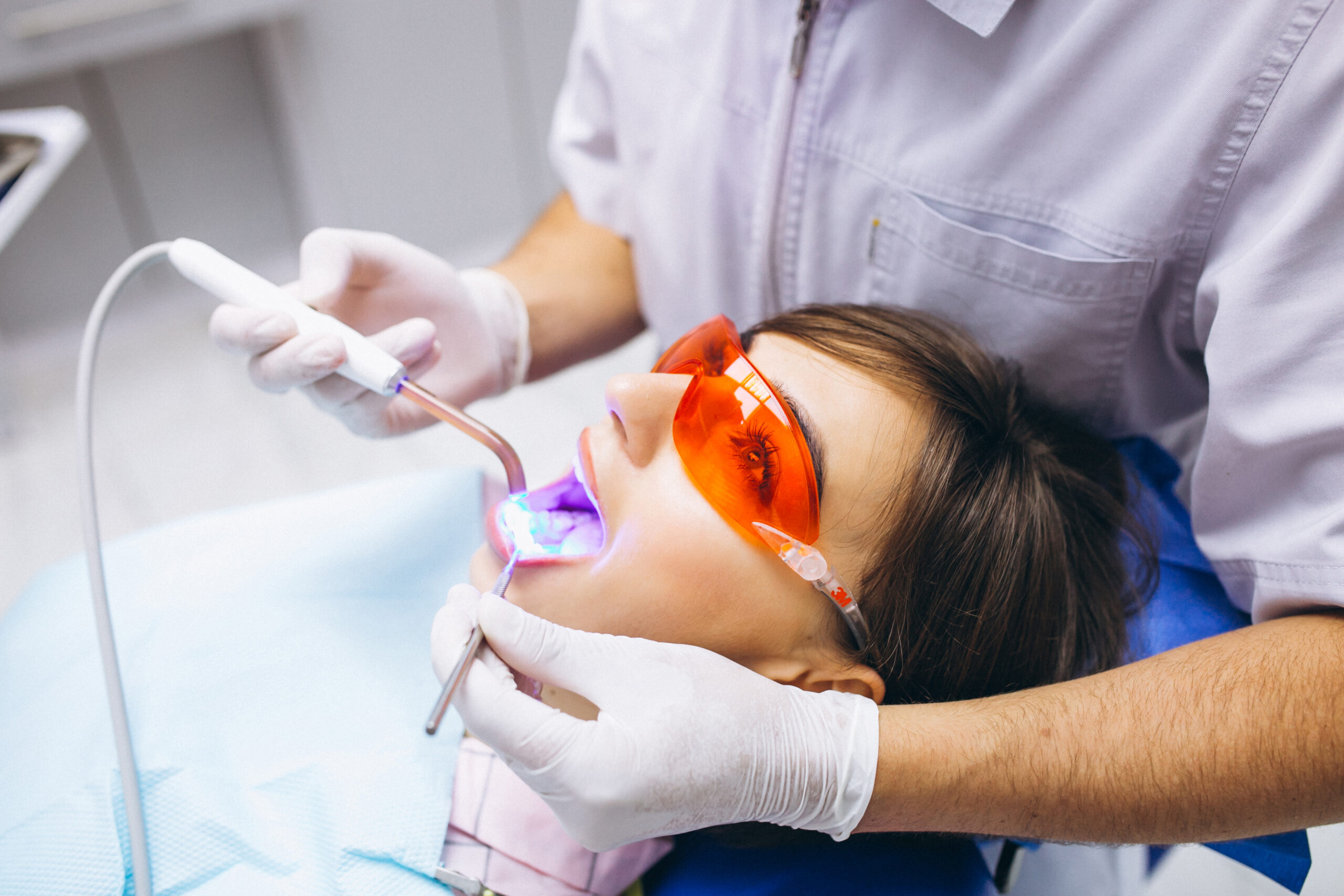 Mulher com trespasse horizontal fazendo tratamento com um dentista.