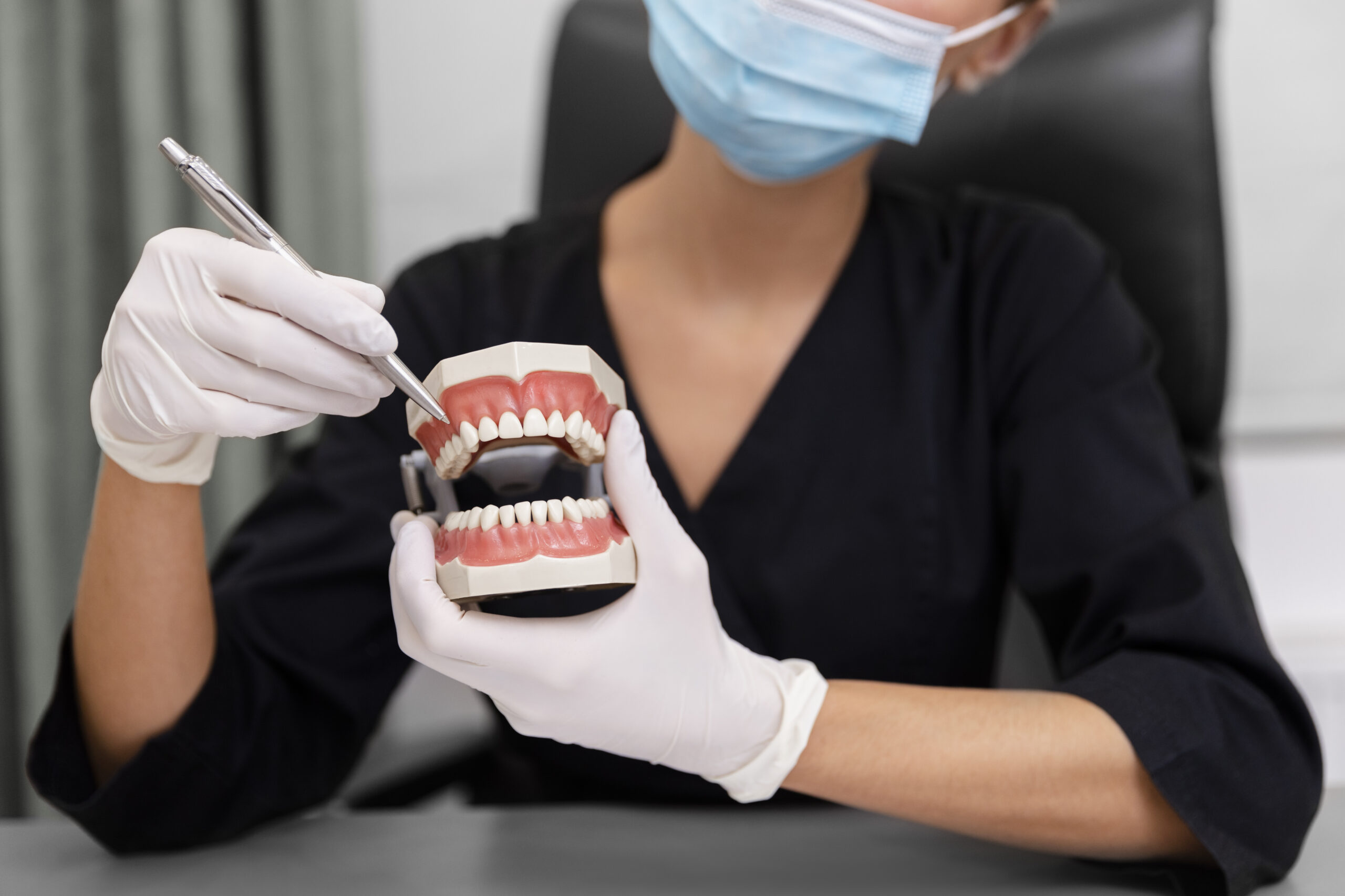 Dentista mostrando ao paciente como cuidar da prótese dentária corretamente