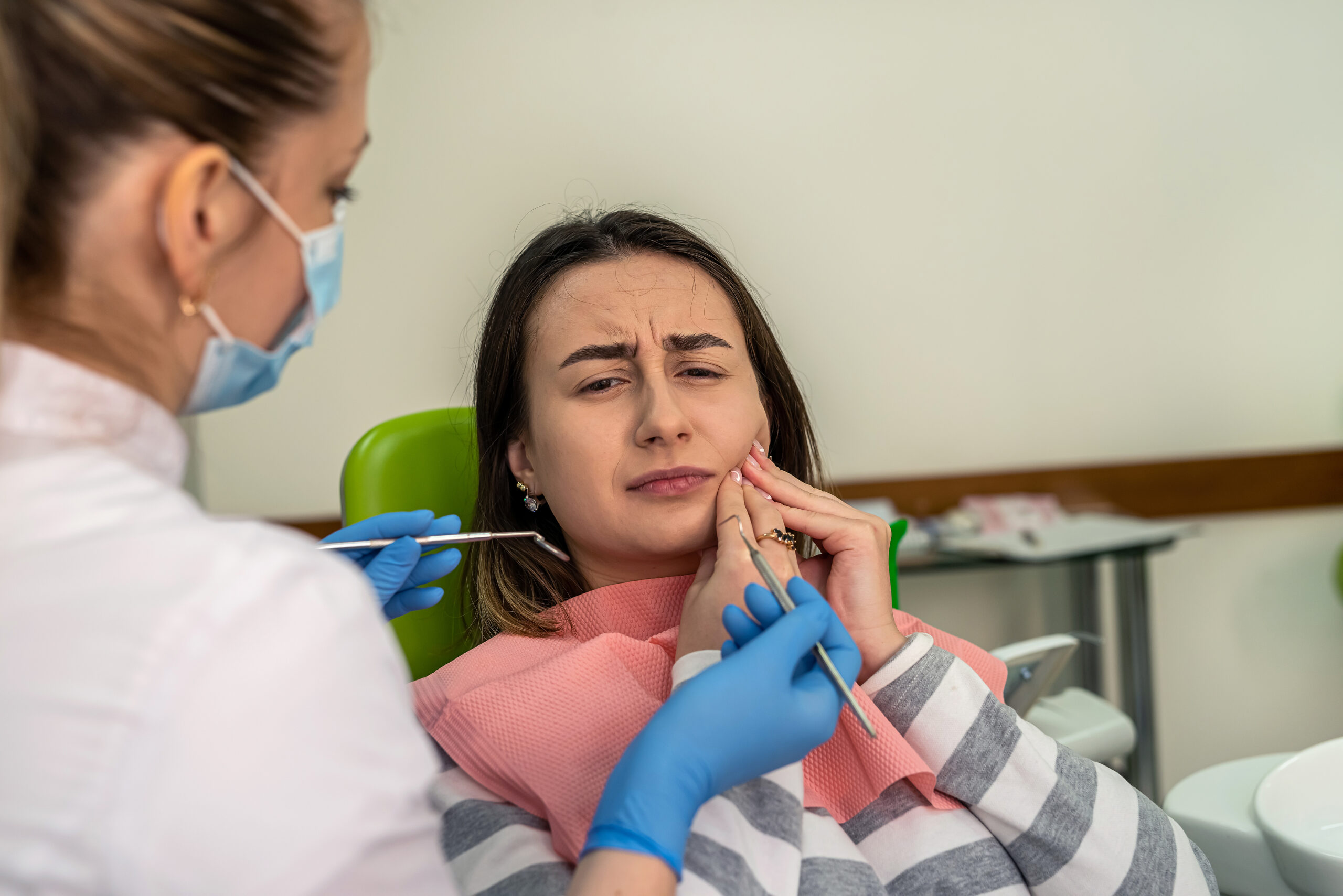 Paciente sendo atendida por sua dentista, para tratar a pericoronarite.