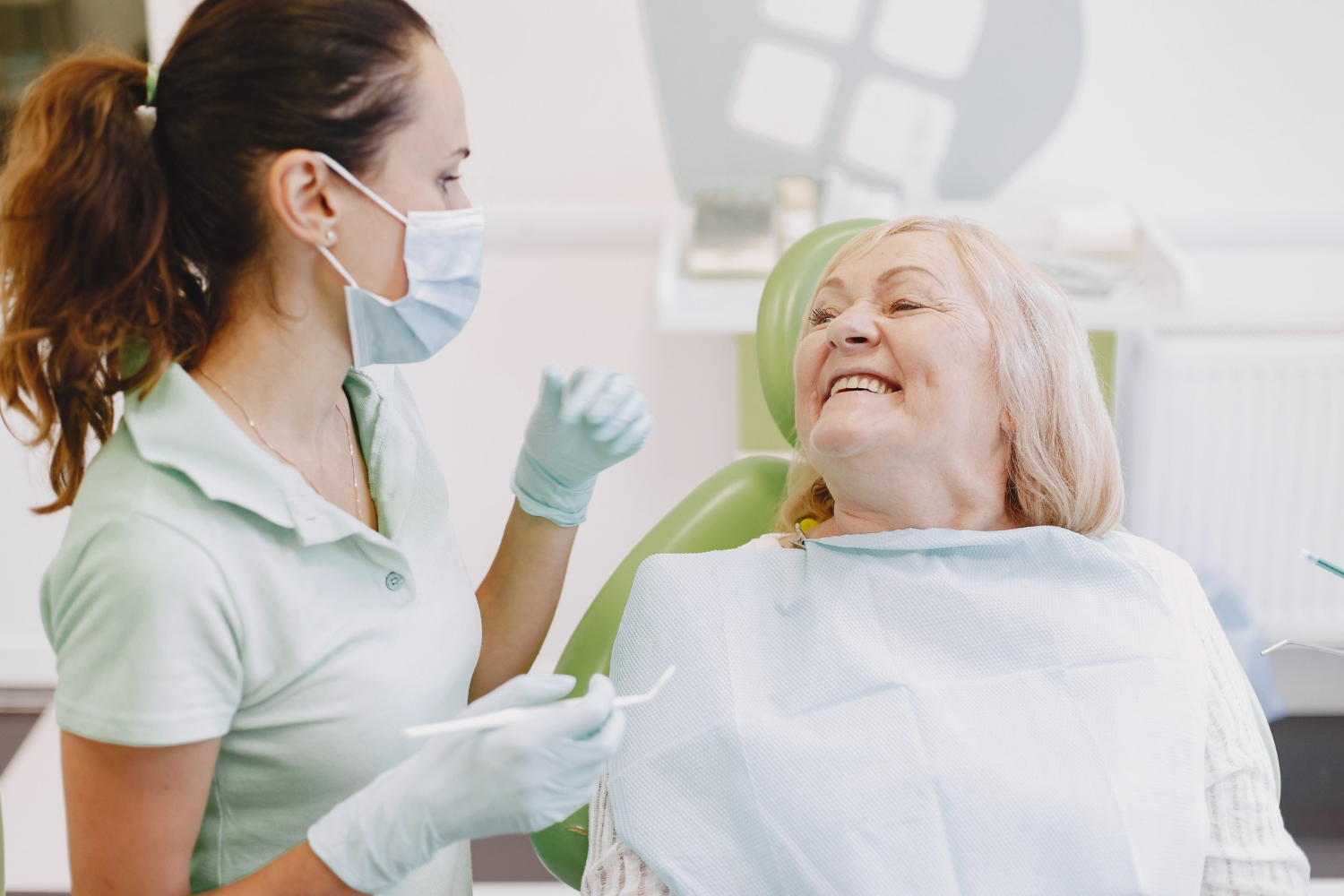 Imagem ilustrativa sobre saúde bucal para idosos mostrando uma mulher idosa sorrindo para sua dentista.