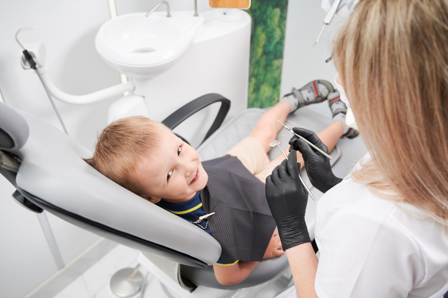 Bebê consultando com o dentista para avaliar a presença de cárie de mamadeira em seus dentes.